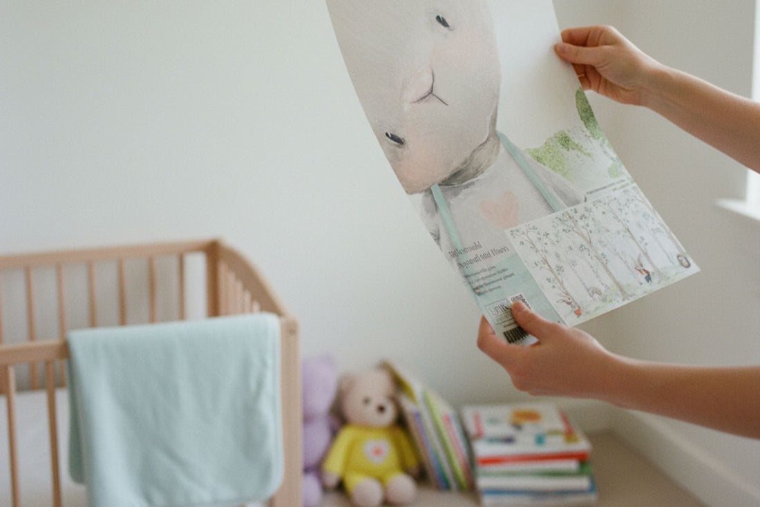 Person hält Tapetenmuster im Kinderzimmer in den Händen