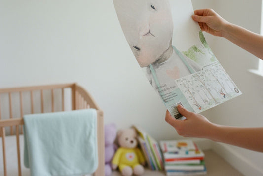 Person hält Tapetenmuster im Kinderzimmer in den Händen