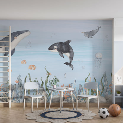 Maßangefertigte Vliestapete mit aquarellierten Meerestieren wie Walen, Fischen und Korallen im Kinderzimmer.