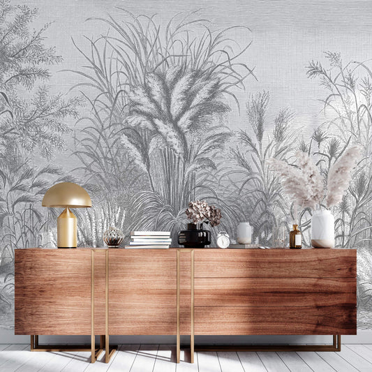 Fototapete mit schwarz-weißem Gräsermuster im Holzschnitt-Stil. Davor steht eine braune Kommode.