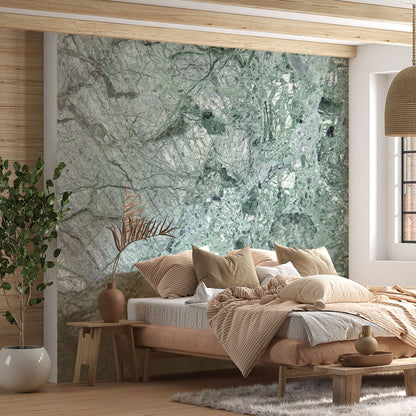 Maßangefertigte Vliestapete mit grünem Marmor-Aquarellmuster in Schlafzimmer mit Holzbettrahmen.