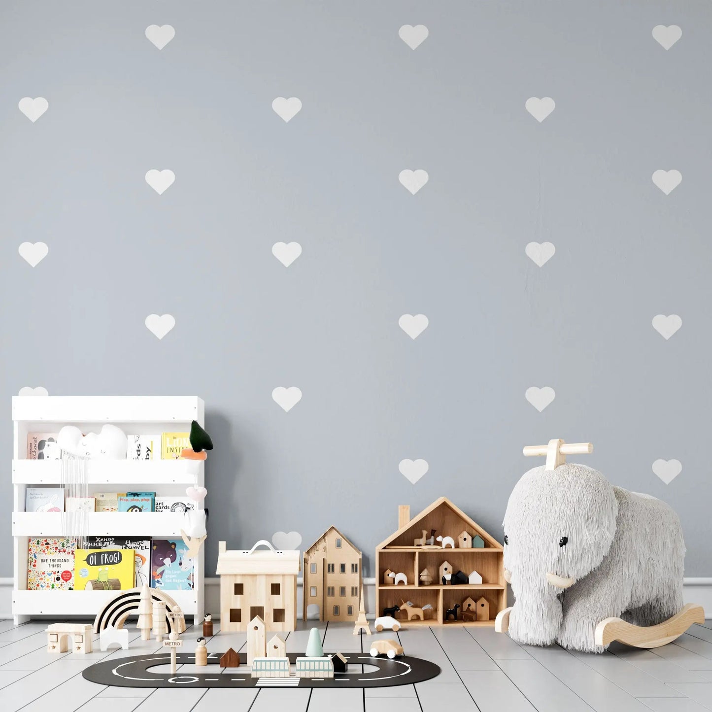 Kinderzimmer mit blauer Mustertapete mit Herzen und Kinderzpielzeug.